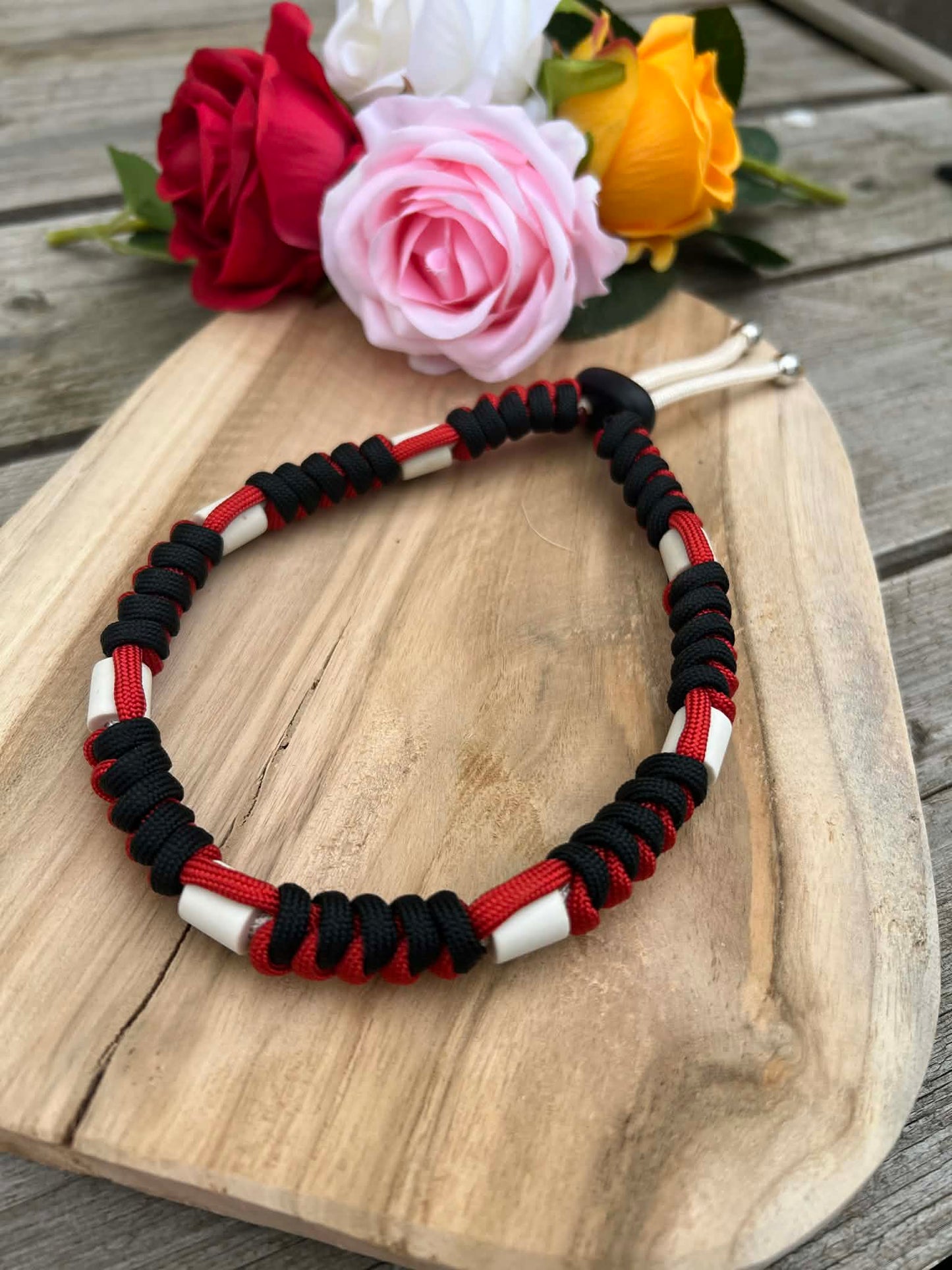 Collier anti-tiques artisanal en paracorde tressée rouge et noir avec perles de céramique EM