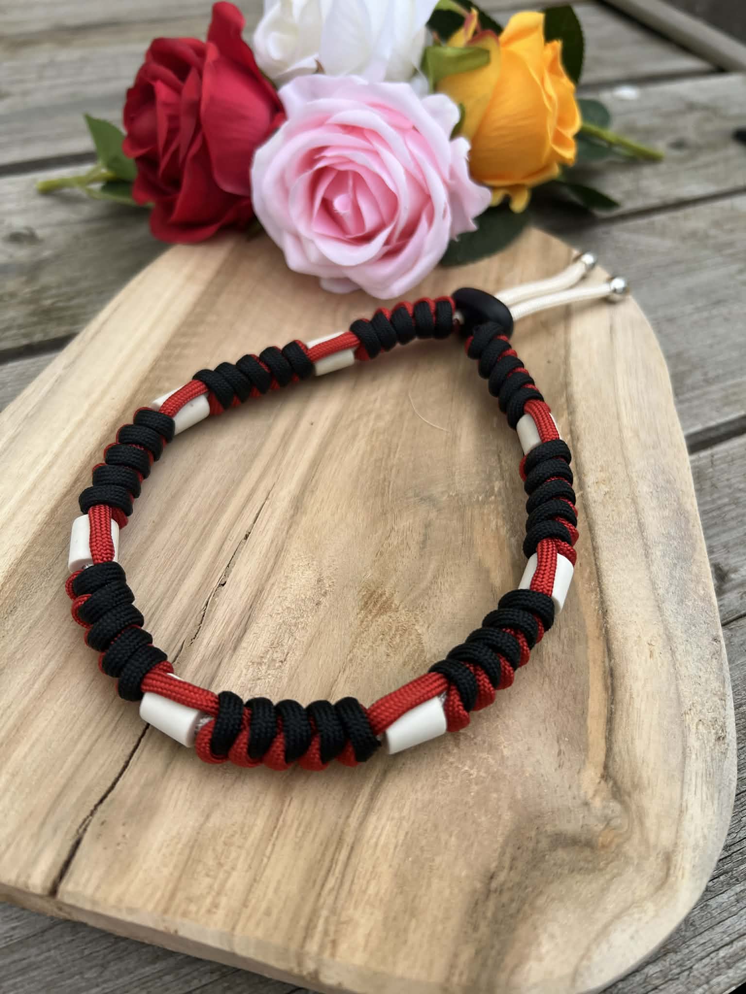 Collier anti-tiques artisanal en paracorde tressée rouge et noir avec perles de céramique EM