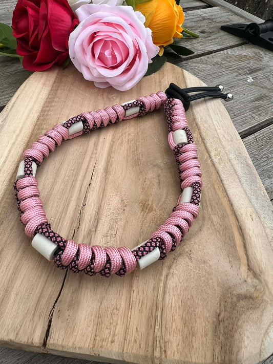 Collier anti-tiques artisanal en paracorde rose avec motif torsadé noir et perles de céramique EM