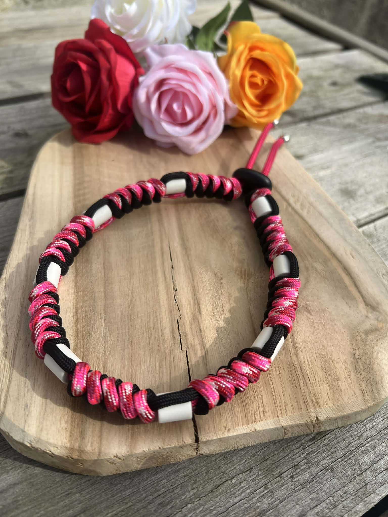 Collier naturel contre les tiques et puces pour animaux sur planche en bois décorée de fleurs